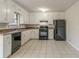 Kitchen with white cabinets, black appliances, and tile floors at 8652 Embrey Dr, Jonesboro, GA 30236