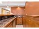 Basement wet bar with dark marble countertop and wood cabinets at 1426 Greenridge Trl, Lithonia, GA 30058
