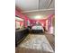 Main bedroom with pink walls, large bed, and lots of natural light at 985 Farrington Se Pl, Atlanta, GA 30315