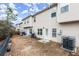 View of the backyard showing the townhome exterior, multiple AC units, and a grassless lawn at 7174 Fringe Flower Dr # 21, Austell, GA 30168