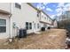 View of the backyard showing the townhome exterior, multiple AC units, and a grassless lawn at 7174 Fringe Flower Dr # 21, Austell, GA 30168
