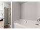 This bathroom features a white bathtub, tile floor, a frosted glass shower, and neutral walls at 7174 Fringe Flower Dr # 21, Austell, GA 30168