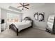 Spacious bedroom with a ceiling fan, a tray ceiling, a queen bed, and bright windows at 7174 Fringe Flower Dr # 21, Austell, GA 30168