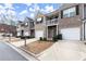 A line of modern townhomes featuring brick and siding exteriors, each with its own garage and covered front entry at 7174 Fringe Flower Dr # 21, Austell, GA 30168