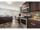Modern kitchen with stainless steel appliances and hardwood floors leading into living spaces at 7174 Fringe Flower Dr # 21, Austell, GA 30168