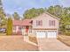 Tan two-story house with red shutters, double garage, and landscaped yard at 108 Ivy Trace Ln, Dallas, GA 30157