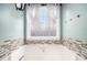 Stylish bathroom tub with ceramic tile and a window providing natural light at 118 Gilberts Way, Temple, GA 30179