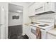 The kitchen is equipped with white appliances, white cabinets, and tan countertops at 1525 Terrell Mill Se Pl # A, Marietta, GA 30067