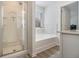 Well-lit bathroom featuring a glass shower, a tub, and neutral-toned walls at 4722 Blake Loop, Atlanta, GA 30349
