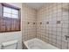 Clean bathroom with tile shower/tub and wood shuttered window at 3898 Buckland Dr, Lilburn, GA 30047