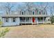 Two-story house with a covered porch and a red door at 3898 Buckland Dr, Lilburn, GA 30047