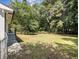 Spacious backyard featuring a large grassy lawn, mature trees, and a partial view of the home's exterior at 3453 Eisenhower E Cir, Atlanta, GA 30354