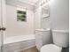Bathroom with a white tile shower-tub combo, and a window providing natural light at 3453 Eisenhower E Cir, Atlanta, GA 30354