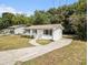 Charming white painted home with a long driveway and a lush, green, tree-filled yard at 3453 Eisenhower E Cir, Atlanta, GA 30354