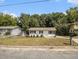 Curb view of a single story home with white paint, a green lawn, and mature shade trees at 3453 Eisenhower E Cir, Atlanta, GA 30354