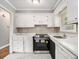 Updated kitchen featuring white cabinets, marble countertops, stainless steel appliances, and sleek tile flooring at 3453 Eisenhower E Cir, Atlanta, GA 30354