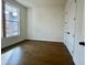 This bedroom features hardwood floors, a large window, and white trim at 515 Cottage Creek Dr, Cumming, GA 30040
