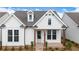 Charming white farmhouse-style home with brick-paved porch and manicured landscaping enhancing its curb appeal at 515 Cottage Creek Dr, Cumming, GA 30040