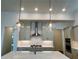 Close-up of the kitchen showing stainless steel appliances, tile backsplash, and pendant lighting at 515 Cottage Creek Dr, Cumming, GA 30040