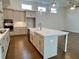 Kitchen island with white countertop, stainless steel sink, and hardwood floors at 515 Cottage Creek Dr, Cumming, GA 30040