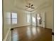 Spacious main bedroom with tray ceiling, ceiling fan, hardwood floors, and ensuite bath at 515 Cottage Creek Dr, Cumming, GA 30040