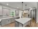 Bright, open kitchen with stainless steel appliances, a large island, and custom gray cabinetry at 8981 Callaway Dr, Winston, GA 30187