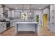 Modern kitchen features gray cabinetry, a large island, stainless appliances, and wood-look floors at 8981 Callaway Dr, Winston, GA 30187
