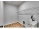Laundry room with a utility sink, laminate floors, and wire shelving at 8981 Callaway Dr, Winston, GA 30187