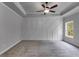A spacious carpeted main bedroom with decorative wall paneling, a ceiling fan, and a large window at 8981 Callaway Dr, Winston, GA 30187