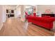 Bright living room with hardwood floors and a red velvet sofa at 312 Amble Side, Mcdonough, GA 30252