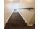 Modern staircase leading upstairs, featuring dark wood steps and a neutral wall at 420 Old Holcomb Bridge Rd, Roswell, GA 30076