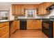 Traditional-style kitchen featuring wooden cabinets, green countertops, and modern black appliances at 490 Dorsey Road Rd, Hampton, GA 30228