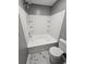 Bathroom with a shower/tub combo, white tile surround, and marble-look floor at 10411 Ivygate Ter, Jonesboro, GA 30238