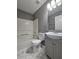 Updated bathroom with gray vanity, white toilet and bathtub, and marble-look floor tiles at 10411 Ivygate Ter, Jonesboro, GA 30238