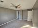 Spacious bedroom with neutral gray walls, carpet flooring, ceiling fan, and ample closet space at 10411 Ivygate Ter, Jonesboro, GA 30238