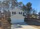 Tan two-story house with white garage door and landscaping at 10411 Ivygate Ter, Jonesboro, GA 30238