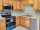 Updated kitchen with stainless steel appliances and wood cabinets at 10411 Ivygate Ter, Jonesboro, GA 30238
