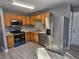 Kitchen with wood cabinets, stainless steel appliances, and gray floors at 10411 Ivygate Ter, Jonesboro, GA 30238