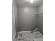 Laundry room with gray walls, wire shelving, and marble-look floor tiles at 10411 Ivygate Ter, Jonesboro, GA 30238