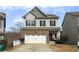 Two-story brick home with a white garage door and a landscaped yard at 135 Cessna Dr, Canton, GA 30114
