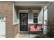 Front porch with a black door, wreath, and pink cushions at 135 Cessna Dr, Canton, GA 30114
