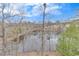 Scenic pond view from a wooded area with several houses visible in the background at 135 Cessna Dr, Canton, GA 30114