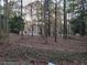 Wooded backyard with a glimpse of a home in the distance at 730 Ponderosa Ct, Fayetteville, GA 30214