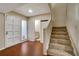 Open foyer featuring hardwood floors, staircase, access to the powder room and front door at 104 Woodhaven Way, Alpharetta, GA 30009