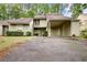 Charming townhome featuring an attached carport and a welcoming entrance with lush landscaping at 104 Woodhaven Way, Alpharetta, GA 30009