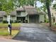 Inviting home with covered carport, lush landscaping, and a 'For Sale' sign on a well-maintained lawn at 104 Woodhaven Way, Alpharetta, GA 30009