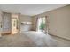 Cozy living room with neutral carpet and sliding glass door to the outside at 104 Woodhaven Way, Alpharetta, GA 30009
