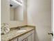 Cozy powder room featuring a granite countertop, vanity and a decorative mirror at 104 Woodhaven Way, Alpharetta, GA 30009