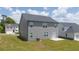 Exterior of the backyard including gray house with green lawn, gray roof, and small patio at 205 Amberjack Trail, Covington, GA 30016