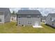 View of backyard featuring a gray two-story house, green lawn, and small concrete patio at 205 Amberjack Trail, Covington, GA 30016